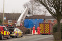 Staffordshire Fire and Rescue personnel stand outside a tarpaulin covered property with a burnt out roof at the scene of a deadly house fire on February 5, 2019 in Stafford, England.