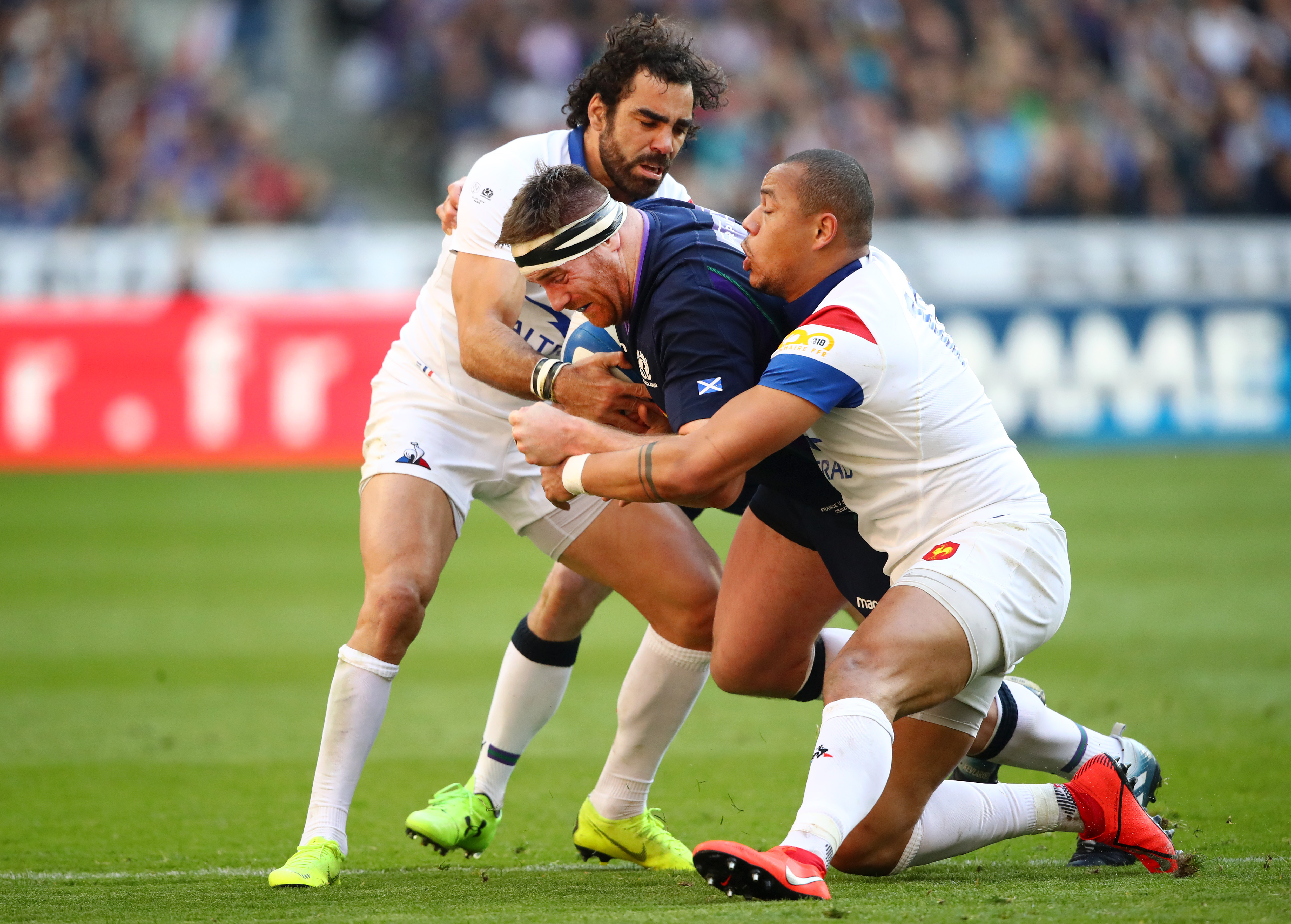 Simon Berghan of Scotland is tackled by Gael Fickou and Yoann Huget in Paris.