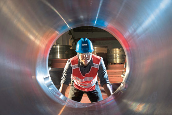 A Weir Group worker inspects a steel pipe