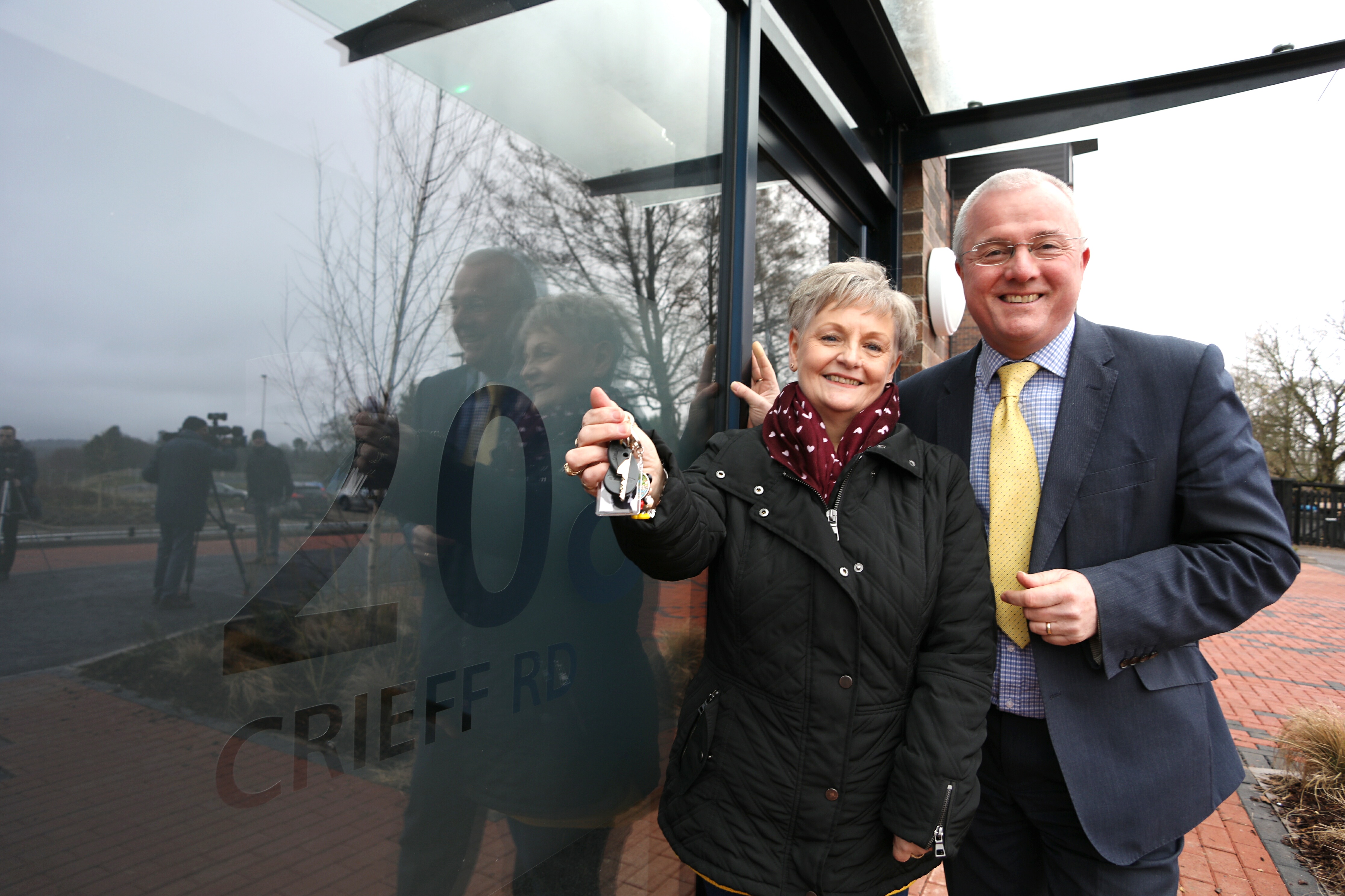 Resident Angela Grainger with housing and communities convener Peter Barrett and the keys to her new flat.