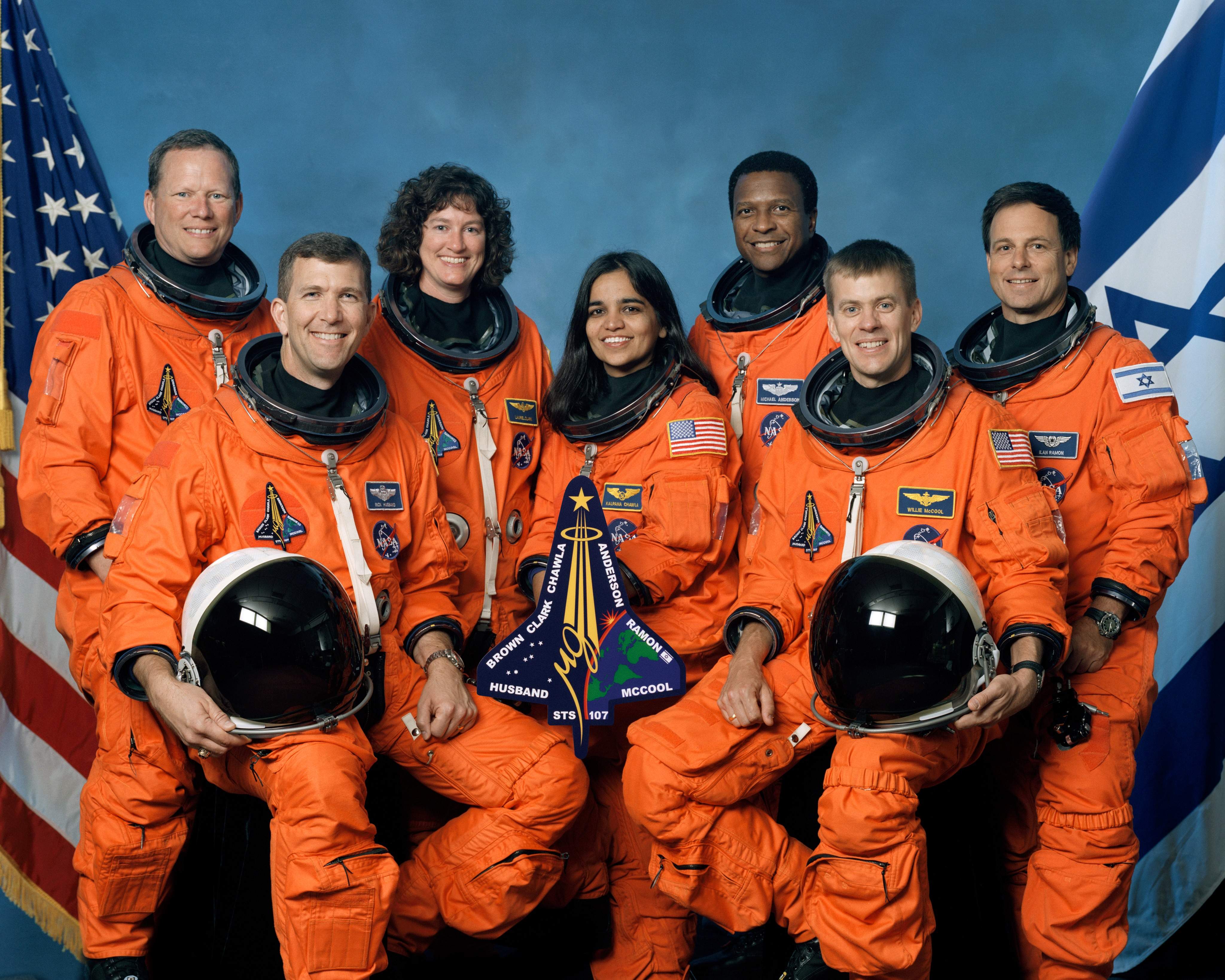 The crew of Space Shuttle Columbia's mission STS-107 take a break from their training regime to pose for the traditional crew portrait. Seated in front are astronauts Rick D. Husband (L), mission commander; Kalpana Chawla, mission specialist; and William C. McCool, pilot. Standing are (L to R) astronauts David M. Brown, Laurel B. Clark, and Michael P. Anderson, all mission specialists; and Ilan Ramon, payload specialist representing the Israeli Space Agency.