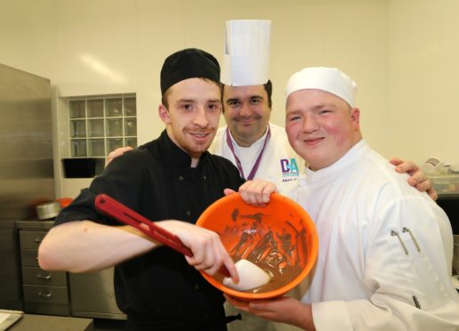 Albert Close with patisserie students Shaun Donovan and James Gilbride mixing melted chocolate to make petits fours.