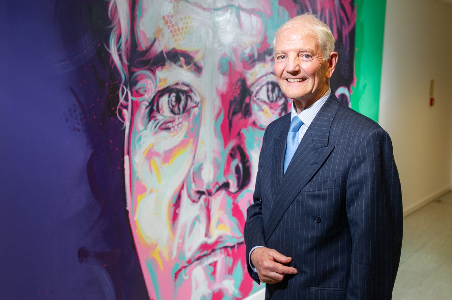 Jim Adamson alongside the portrait of him unveiled at NCR Dundee headquarters.