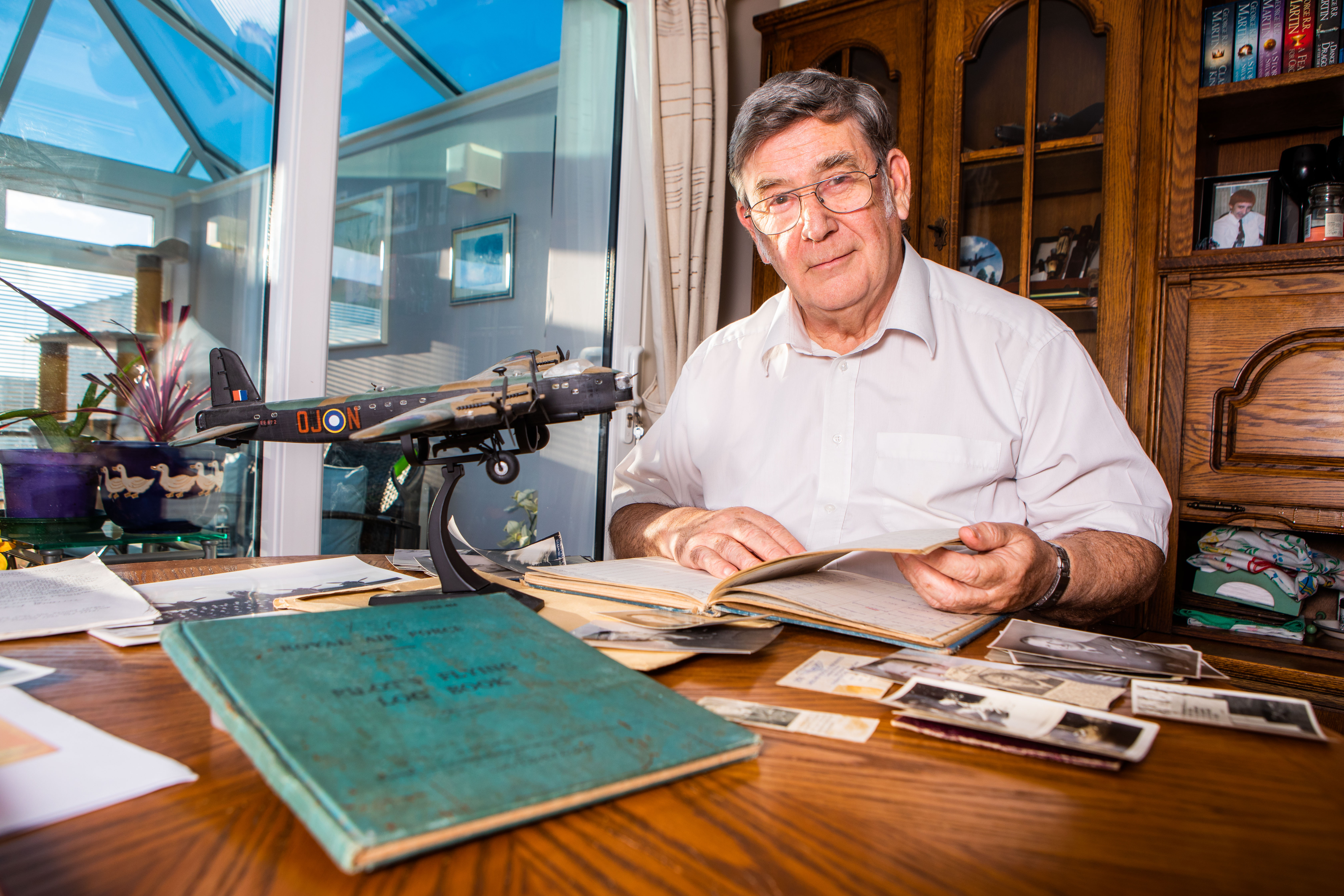 Alan Fraser looks through pictures and official documents in relation to his uncle's RAF service during World War Two.