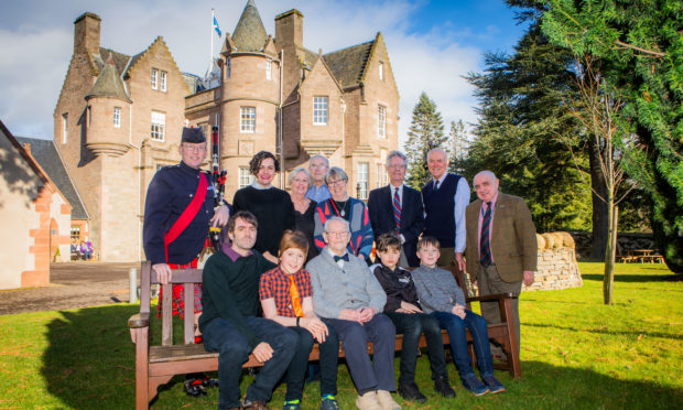 On the bench, left to right, is Alastair Hughson (grandson), Jamie Hughson (great grandson), Tom Wilson, Miller Spencer (great grandson) and Jude McCraw (great grandnephew). Standing, left to right is Pipe Major Alastair Duthie, Rosslyn Spencer (granddaughter), Glynis McCraw (niece), Derek McCraw (Glynis's husband), Doreen Wilson (Tom's daughter), George Wilson (son-in-law), Lt Col R M Riddell (Chair of The Black Watch Association) and Major R J W Proctor MBE (Secretary, The Black Watch Association).