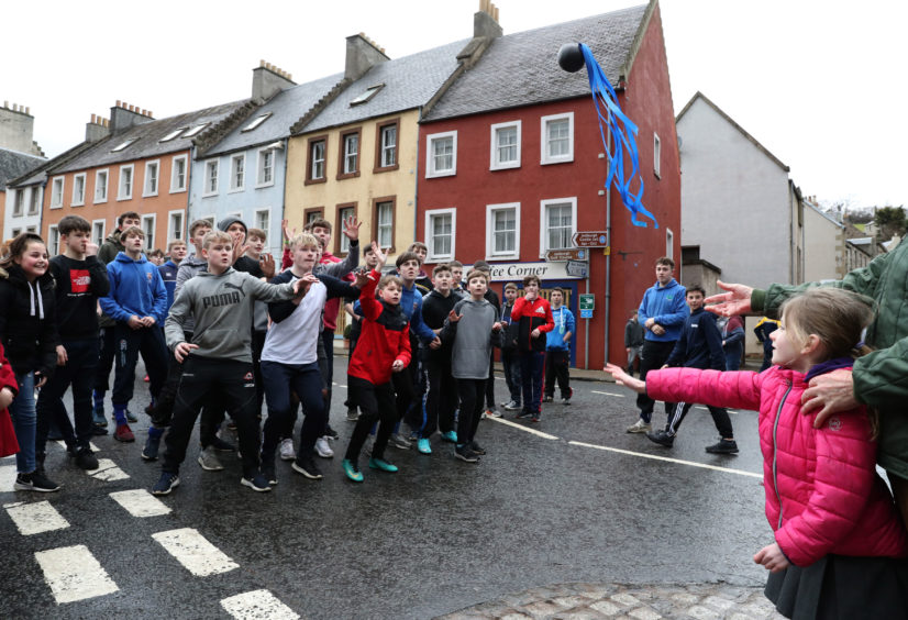 Lois Porterfield from Jedburgh throws in the leather ball during the annual 'FasternÕs E'en Hand Ba' event on Jedburgh's High Street in the Scottish Borders.representing hair, is thrown into the crowd to begin the game.