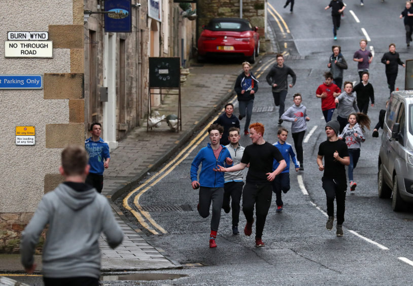 Boys run with the leather ball down a side street during the annual 'FasternÕs E'en Hand Ba' event on Jedburgh's High Street in the Scottish Borders.