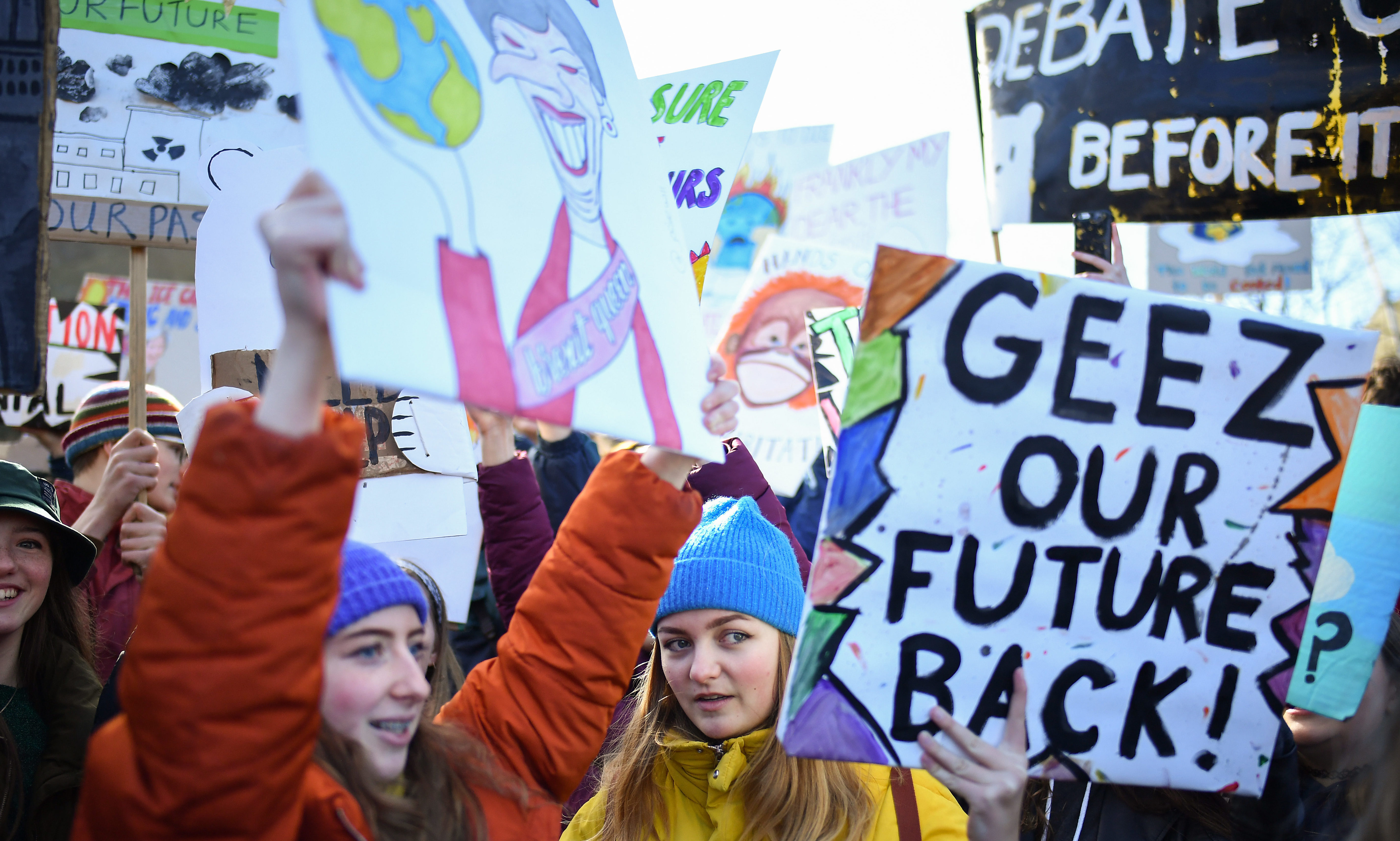 School children hold placards and shout slogans as they participate in a protest outside the Scottish Parliament.