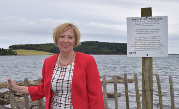Mrs Laird at the warning sign on the foreshore