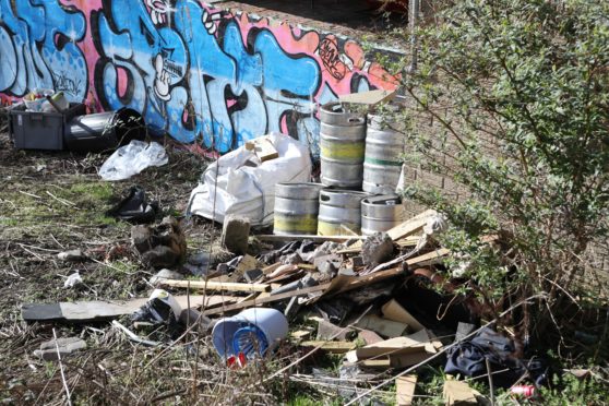 The land between the Dragon's Den pub and the electric car charging port has become a "dumping ground".