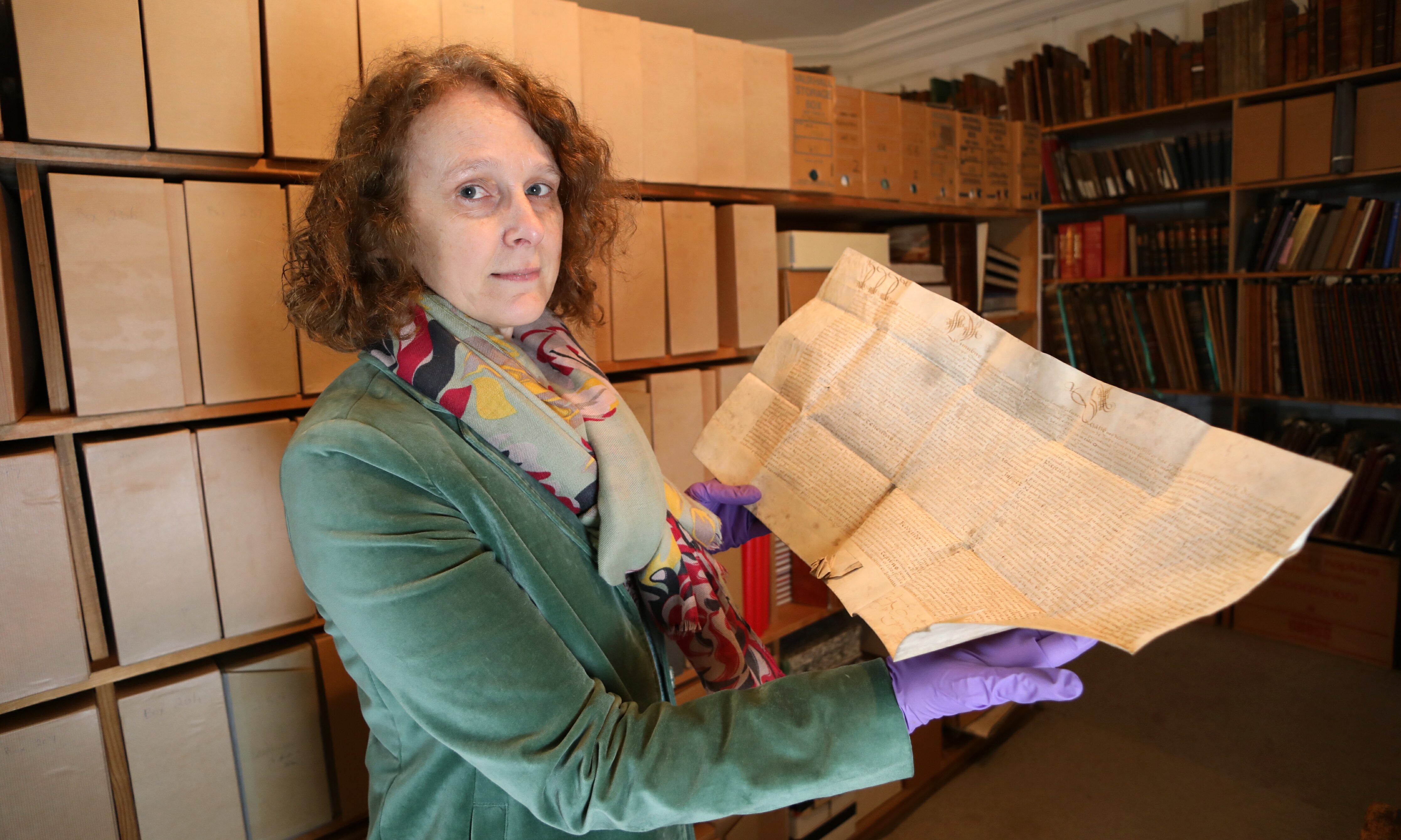 Curator Ingrid Thomson looks at a charter by Mary Queen of Scots in favour of John ,Lord of Glamis, of various lands in the shires of Forfar & Perth.