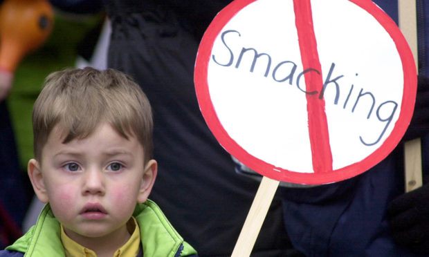 A young child holds an anti-smacking placard on the march to Downing Street, London.