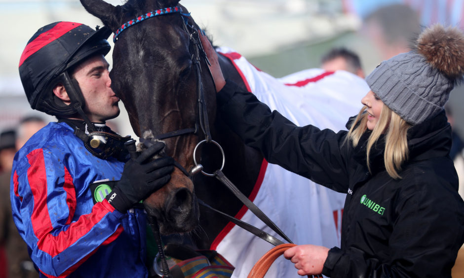 Jockey Jeremiah McGrath kisses horse Beware The Bear after winning the Ultima Handicap Chase. Simon Cooper/PA