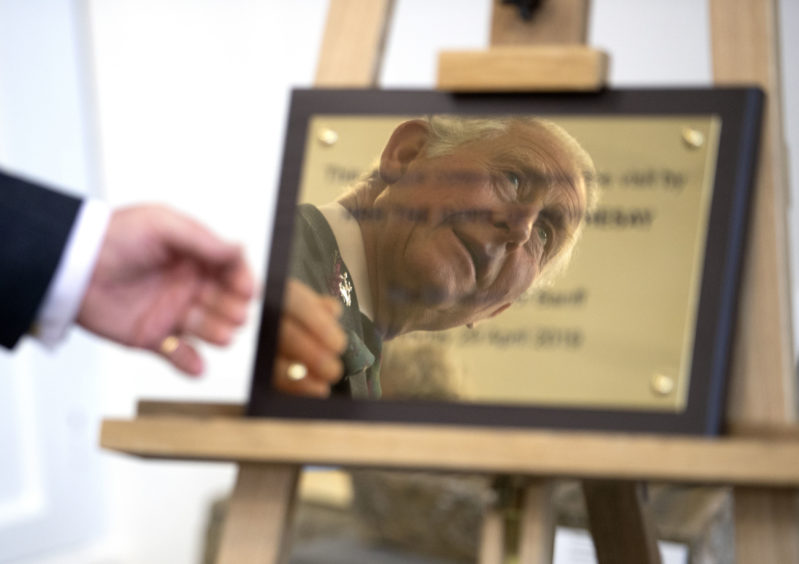 The Prince of Wales, known as the Duke of Rothesay while in Scotland, unveils a plaque during a visit to the Banff Museum in Banff, Aberdeenshire.