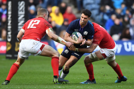 Adam Hastings tries to breach the Welsh defence.
