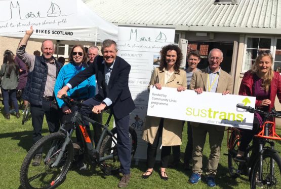 Wille Rennie on his bike, Wendy Chamberlain and Liberal Democrat councillor Bill Porteous are holding the Sustrans sign.