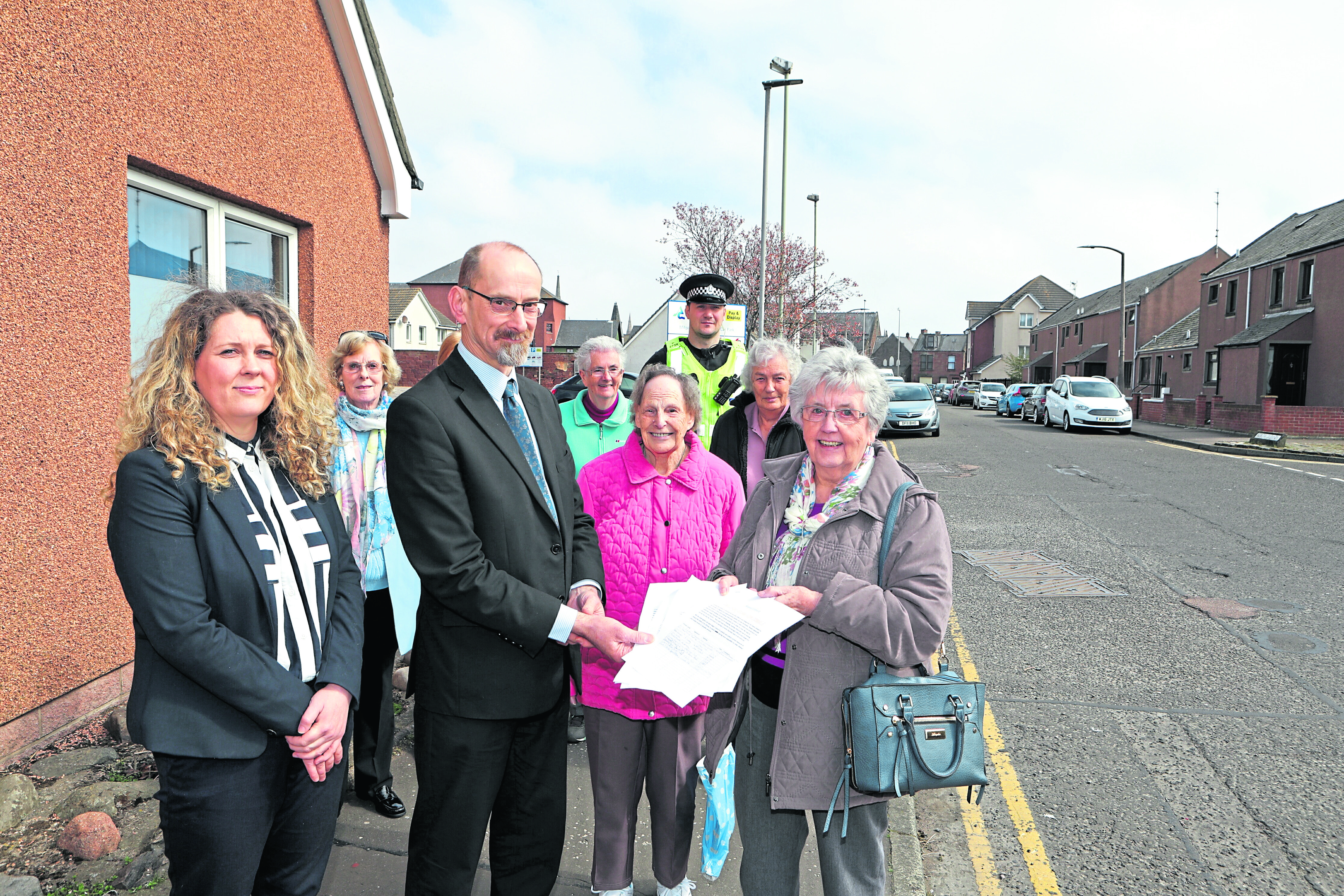 Evelyn Young and other members of the group with Lois Speed and PC David Voigt, handing a petition to Ian Cochrane , director of Infastructure Services at Angus Council