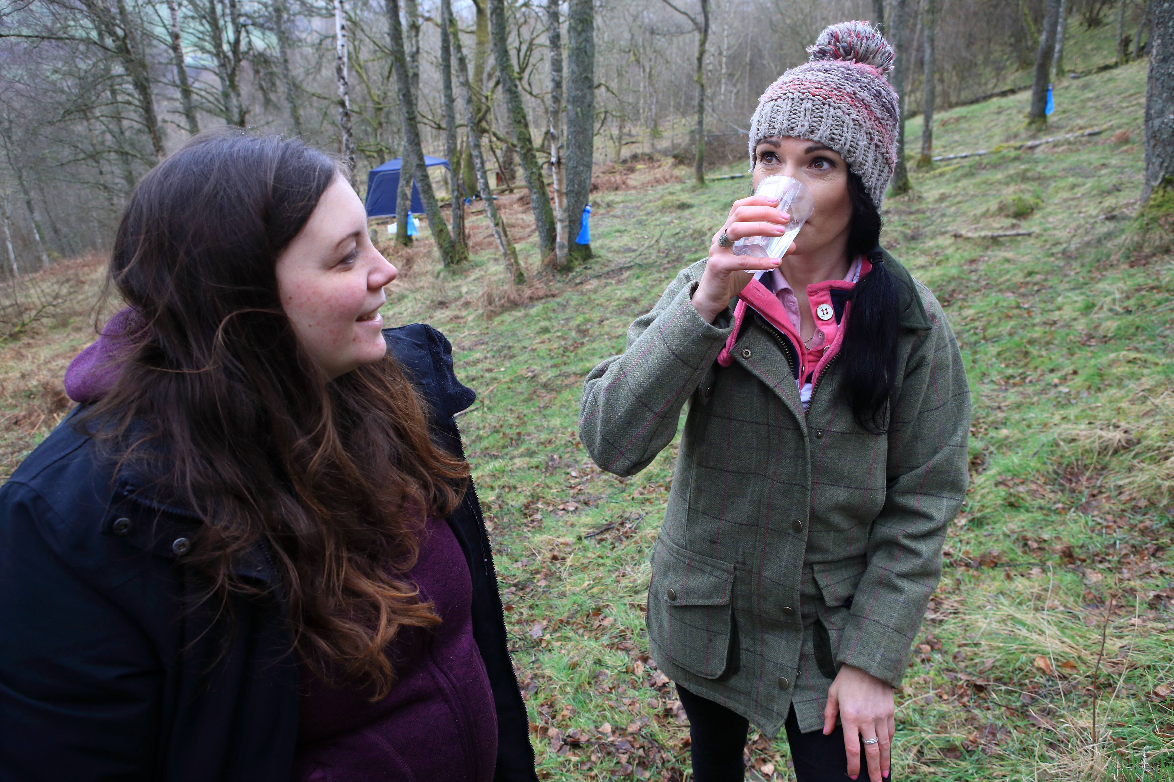 Gayle Ritchie enjoys birch water fresh from the tree while Gabrielle Clamp of Birken Tree looks on.