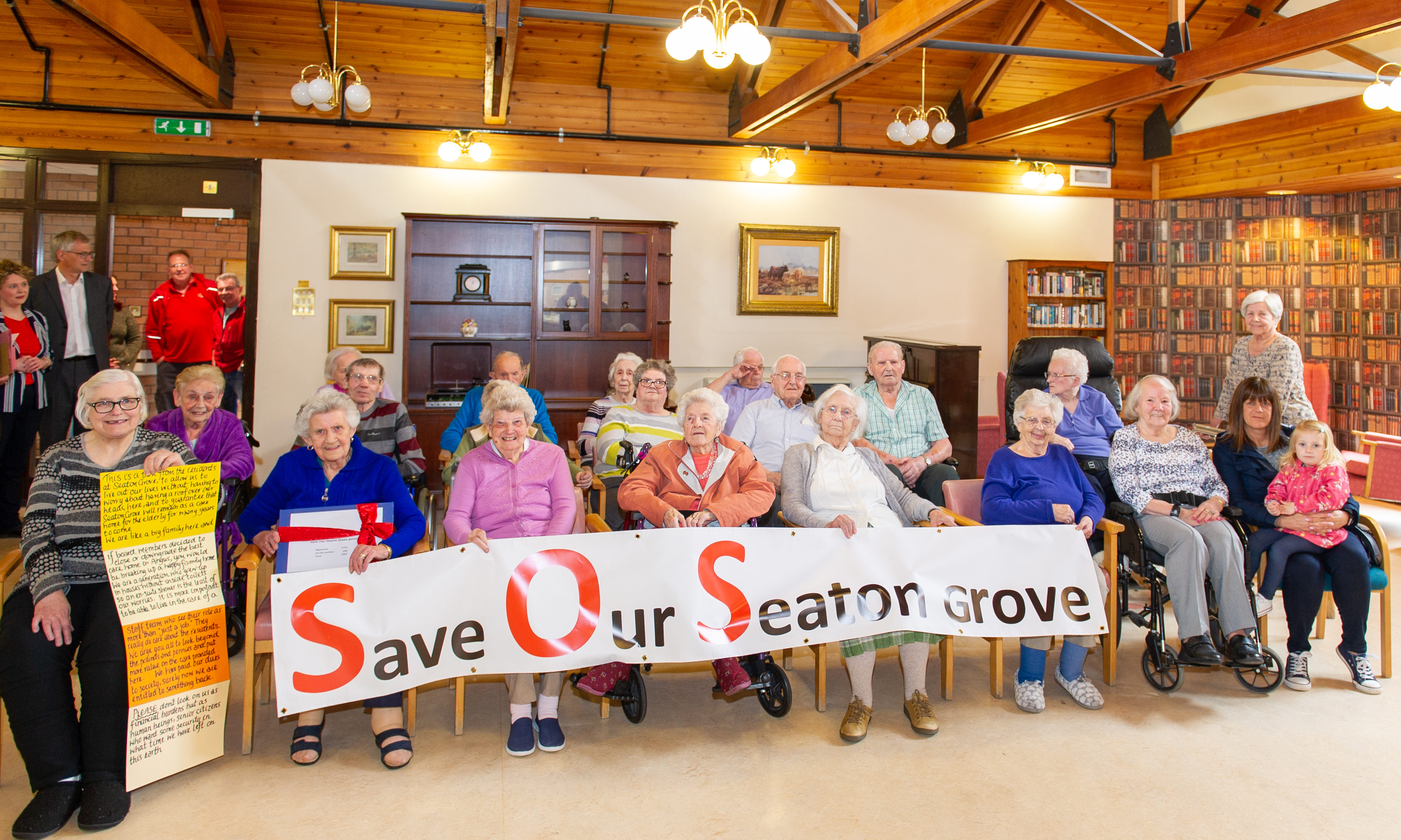 Some of the residents and supporters with the banner made to highlight the potential closure of the facility.