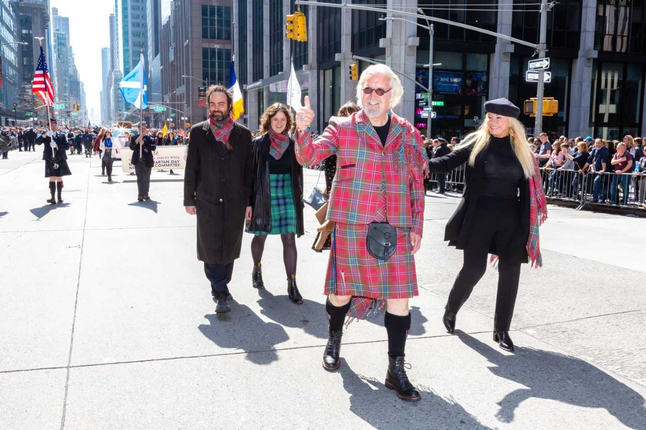 Sir Billy Connolly leading the New York City Tartan Day Parade as Grand Marshal on Saturday in front of around 30,000 spectators, accompanied by family including his wife Pamela (right).