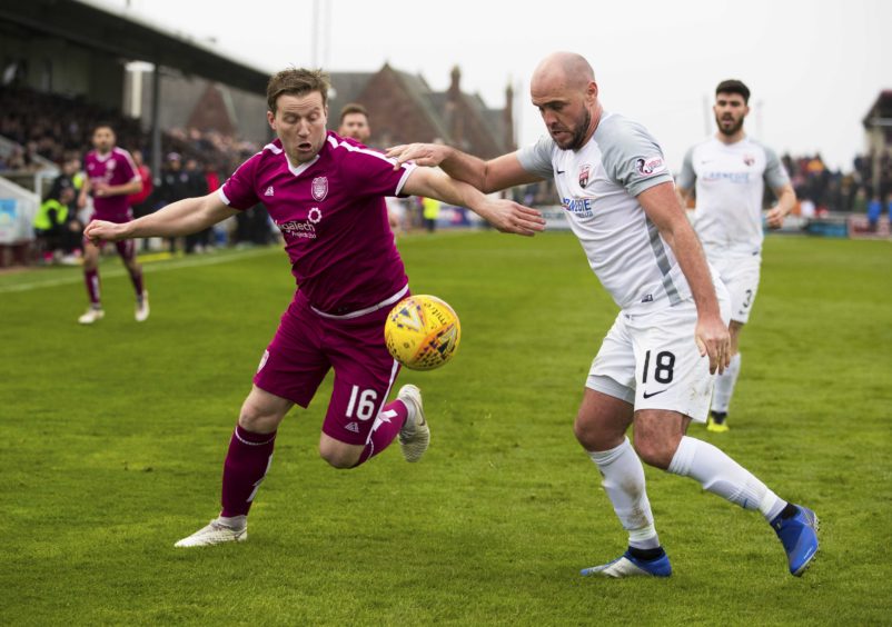 Arbroath's Steven Doris (L) in action with Montrose's Iain Campbell.