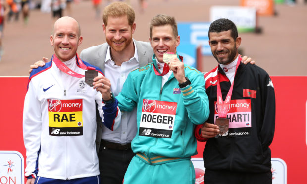The Duke of Sussex poses for a picture with Great Britain's Derek Rae (left), Australia's Michael Roeger and El Harti (right) after receiving their medals in the WPA Marathon during the 2019 Virgin Money London Marathon.