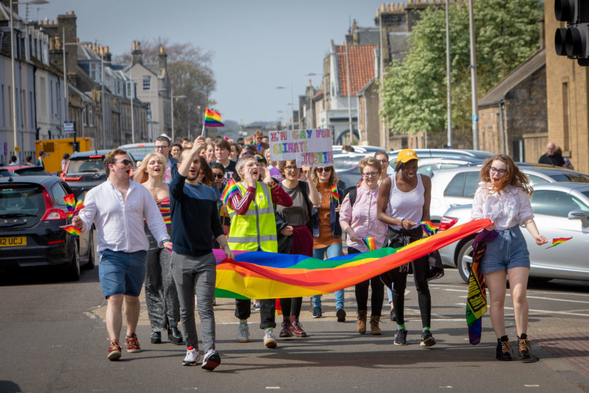 The student Pride parade winds its way through the streets of St Andrews.