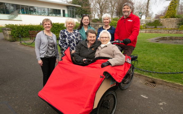Residents of The Beeches Care Home try out the trishaws in Pittencrieff Park.  Group pic includes Cllrs Judy Hamilton, Helen Law and Jean Hall Muir alongside Ruth Ray (Trustee and Sports Convener for Carnegie Dunfermline Trust) and volunteer Frank Waterworth.