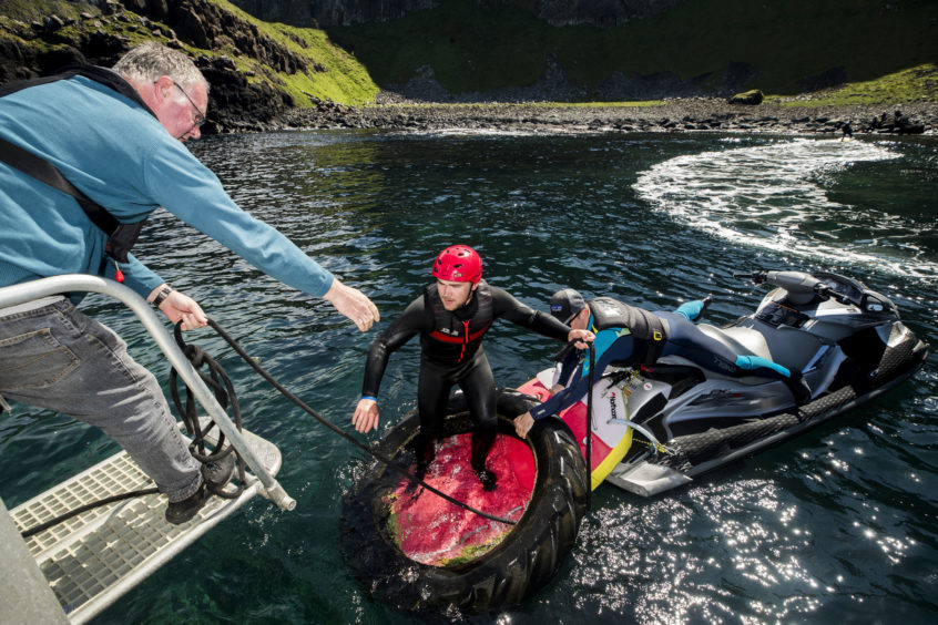 Volunteers load rubbish onto a boat during a litter pick around the coastline of the Giant's Causeway in Northern Ireland.