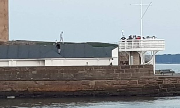 Youths were seen climbing on the roofs of buildings.