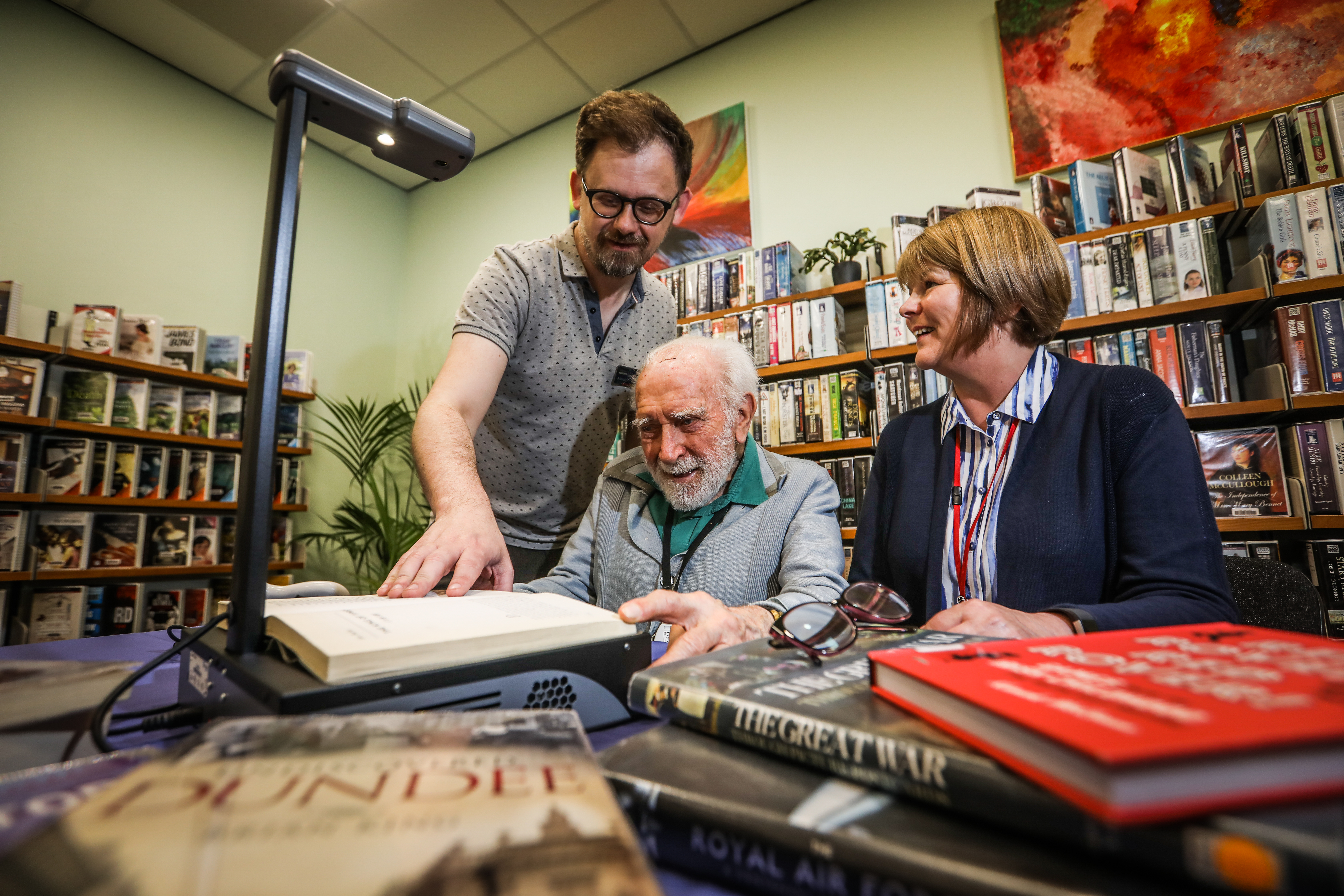 (L-r) Alistair Wilson, library and information worker, Geoffrey Hillyard, who is trying out the device, and Carole Martin from Scottish War Blinded