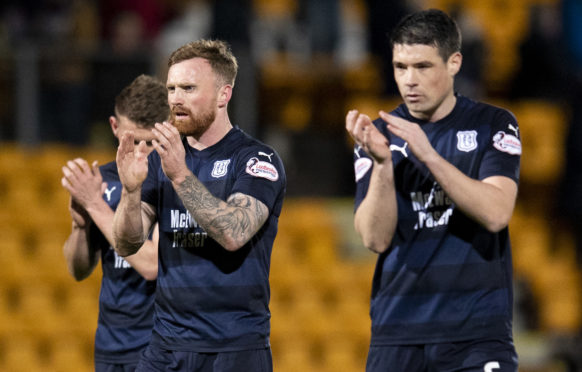 The Dundee players applaud their fans at full-time.