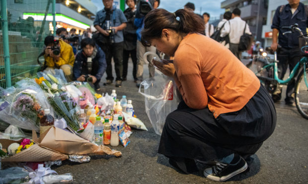 A woman prays at the scene of a knife attack on a group of schoolchildren.
