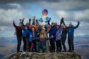 Douglas Roulston, centre, and his support crew celebrating after lifting Oor Nevis to the top of the UK’s highest mountain.