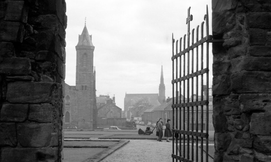 Looking through one of the Abbey Church doors to the churches and the town of Arbroath across the former cloisters of the Abbey. 1963.