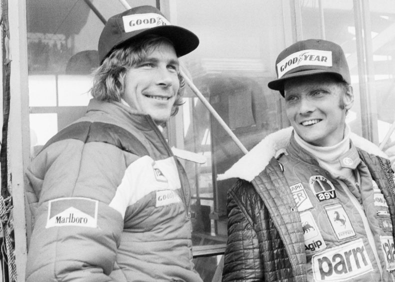 1976, file photo, Austrian auto racer Niki Lauda, right, defending champion in world driving, and James Hunt, of Britain, look at the rain before the start of the Japan Grand Prix Formula One auto race at Fuji International Speedway, Gotemba, Japan. Three-time Formula One world champion Niki Lauda, who won two of his titles after a horrific crash that left him with serious burns and went on to become a prominent figure in the aviation industry, has died. He was 70.