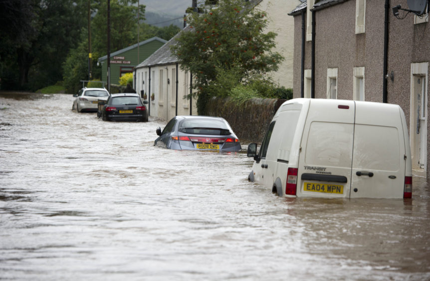 Cars parked outside houses in several feet of flood water along Camp Road, Comrie, in August 2012.