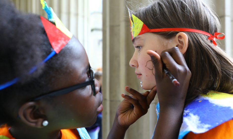 Salimatah Drammah puts the finishing touches to Lilly Webster's face. They are from the Douglas Library group.