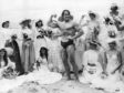 Arnold Schwarzenegger, the film actor who first became famous as Mr Universe for his magnificent physique, on Cannes beach during the Film Festival with the girls from the Folies Bergere.