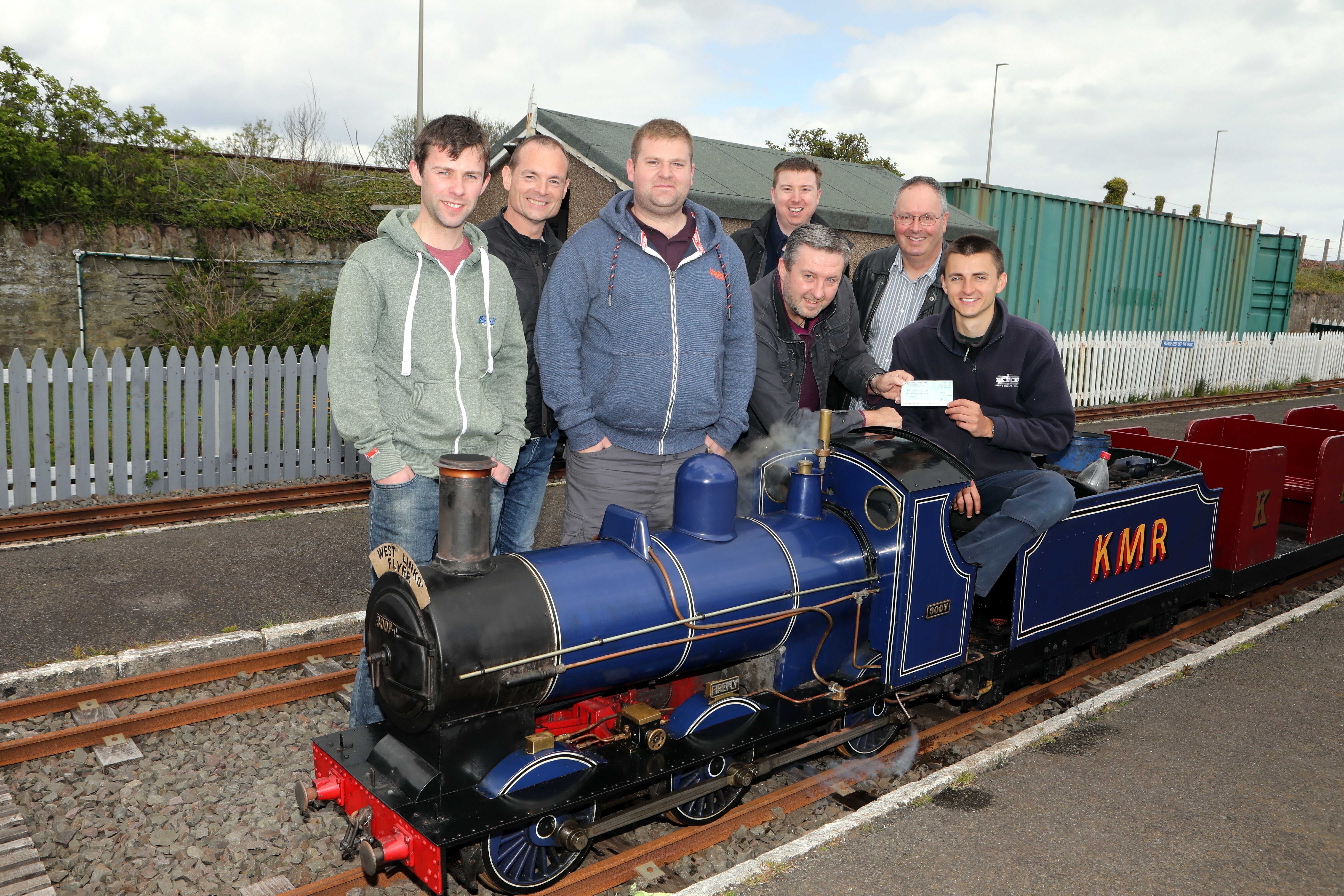 John Kerr of  Kerr's Miniature Railway in Arbroath receives the cheque from Richard Birse, Steven Brykajlo, Jordan Kearney, Derek Hoskins, Guy Houston and Jim Ramsay of Scot-Rail.co.uk