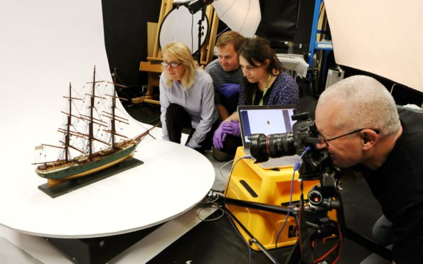 Staff work on capturing images of a three-masted ship — one of 139 in the collection