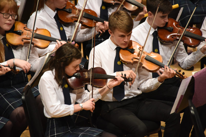 Group of young musicians playing violins
