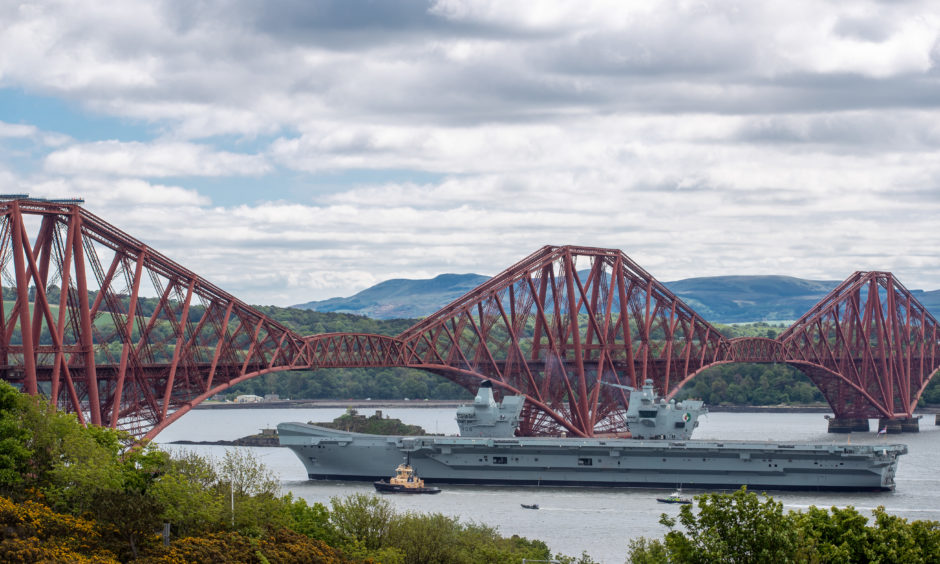 HMS Queen Elizabeth sails under the Forth Bridges as she heads south from Rosyth after completing some routine maintenance work in the dockyard.