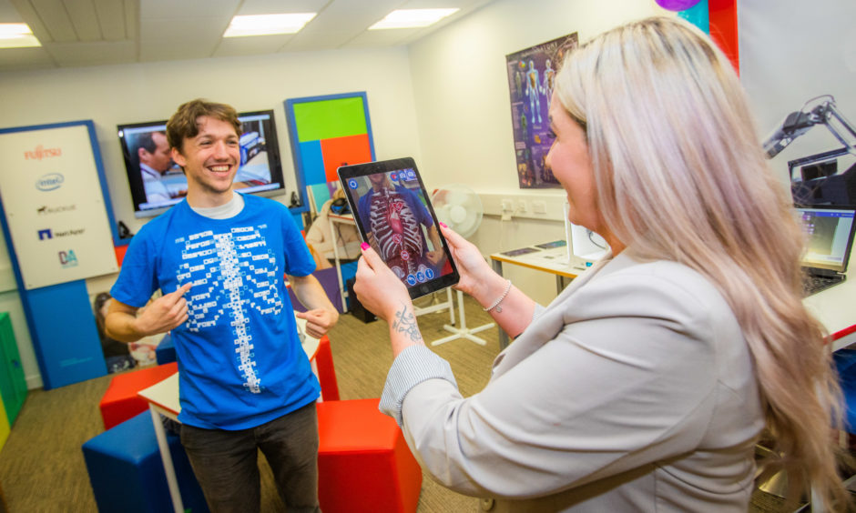Fujitsu Innovation Hub opens at Gardyne Campus of Dundee & Angus College. Picture shows Sam Wain (from Monifieth - studying to teach English as a second language) trying on the t-shirt that allows for AR technology alongside Vickie Craig (Dundee & Angus College, staff).