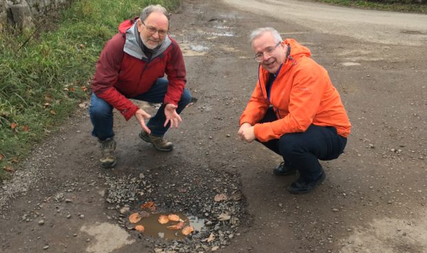 Mr Tepp, right and Councillor Tim Brett survey a large pothole