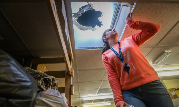 Colleen Mackie, assistant manager, looking up to the damage in the roof.