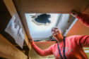 Colleen Mackie, Assistant Manager looking up to the damage in the roof following the near-miss in Forfar last month.