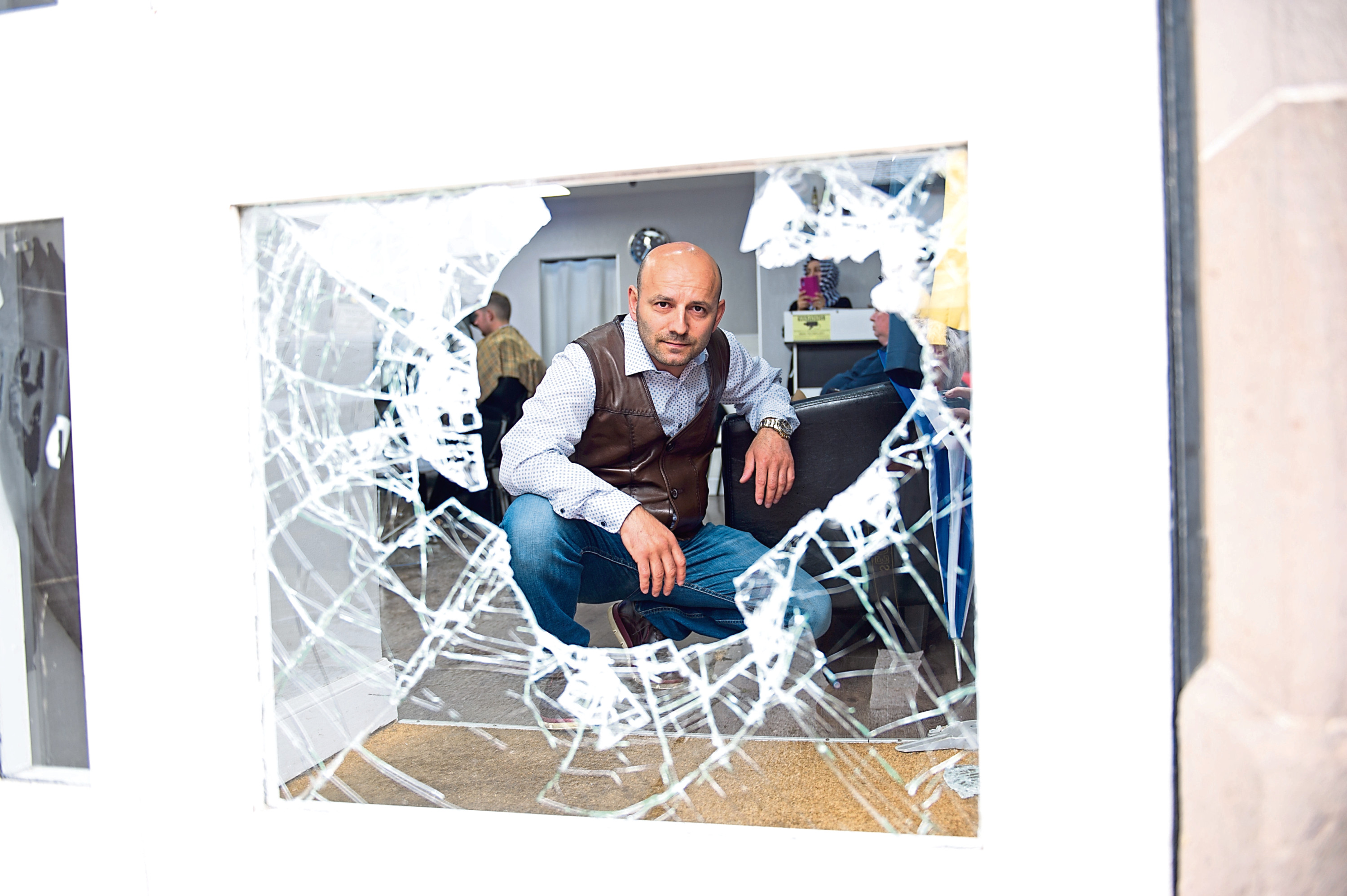 Sinan Durmus, owner of the Turkish Barbers, surveys the damage at his salon