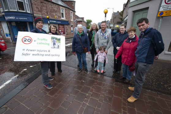 Locals in Coupar Angus promote their 20 MPH speed campaign at the Cross, Organiser Michael Gallagher holding sign