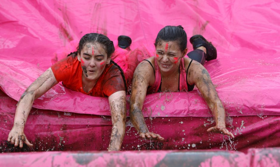 Two participants slide through the muddy obstacles.